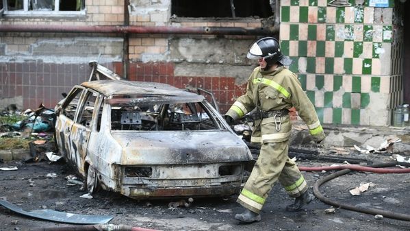 Ein Feuerwehrmann an einem ausgebrannten Auto in Donezk (13. Juni 2022) Bild: Konstantin Mikhalchevsky / Sputnik