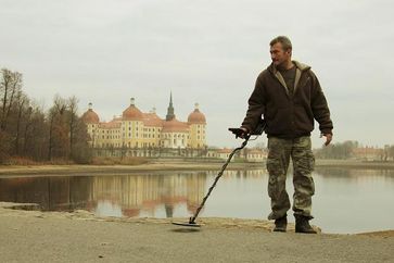 Hanno Marschner entdeckte 1996 den größten Schatz, den je ein Amateursucher in Deutschland gefunden hat: drei Kisten des Millionenschatzes des ehemaligen sächsischen Königshauses. Im Hintergrund Schloss Moritzburg, der ehemalige Sitz der Wettiner. Bild: ZDF und André Götzmann