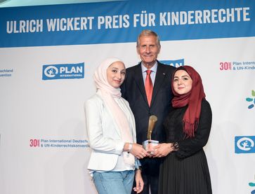 Ulrich Wickert mit den zwei jungen Preisträgerinnen Batoul und Awaz von den "Youth Advocates", die mit dem Sonderpreis ausgezeichnet wurden.