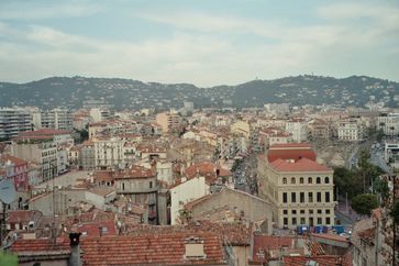 Innenstadt von Cannes vom Osten her gesehen. Am rechten Bildrand das Rathaus mit Bäumen davor. Dahinter der zum Petanque-Spielen genutzte Platz Allées de la liberté