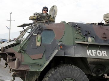 KFOR: Ein deutscher Transportpanzer sichert einen Kontrollpunkt. Bild: Bundeswehr - Steffen Maluche