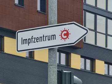 Zum Impfzentrum weisendes Verkehrszeichen