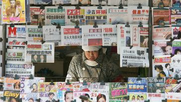 Eine Zeitungsverkäuferin in ihrem Kiosk in Peking Bild: Gettyimages.ru / Guang Niu