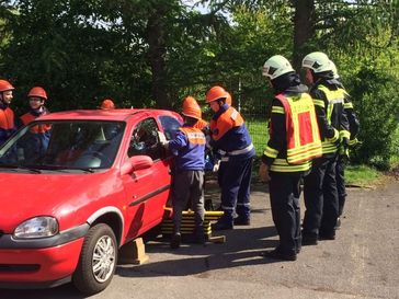 Die Kinder und Jugendlichen der Feuerwehr sichern das Fahrzeug und zerschneiden den PKW.