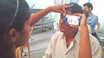 Augen-Screening in Indien: Geschulte Pflegekraft nutzt ein umgerüstetes Smartphone als direkten Augenspiegel Quelle: Foto: privat (idw)