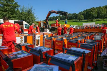 Helferinnen und Helfer der DLRG entpacken und verladen die Bautrockner zum Weitertransport in Ahrweiler.  Bild: DLRG - Deutsche Lebens-Rettungs-Gesellschaft Fotograf: Claudia Dietrich/DLRG
