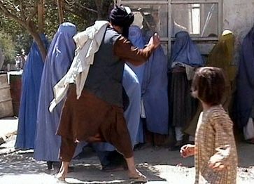 Taliban religious police beating a woman in Kabul on August 26, 2001.