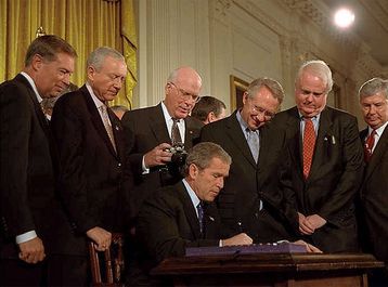 Präsident George W. Bush unterzeichnet den USA PATRIOT Act im Weißen Haus am 26. Oktober 2001. Bild: de.wikipedia.org