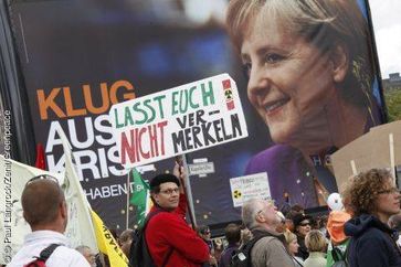 Atomkraftgegner auf der großen Anti-Atom-Demo vor einem Wahlplakat mit Angela Merkel. Bild: Paul Langrock/Zenit/Greenpeace