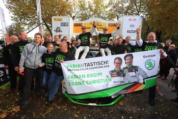 Die neuen deutschen Rallye-Champions Fabian Kreim (D) und Frank Christian (D) feiern nach der Zieldurchfahrt ihren Triumph mit dem BRR-Einsatzteam von SKODA AUTO Deutschland. Bild: "obs/Skoda Auto Deutschland GmbH"