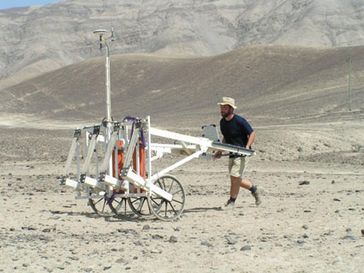 Dr. Thomas Schüler schiebt das Messsystem über eine Geoglyphe in Peru. Foto: IPHT