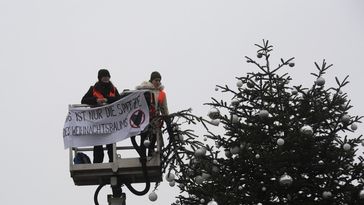 21. Dezember 2022, Berlin: Ohne Spitze steht der Weihnachtsbaum vor dem Brandenburger Tor. Zwei Aktivisten der "Letzten Generation" fuhren mit einem Hubwagen vor den Weihnachtsbaum auf dem Pariser Platz am Brandenburger Tor. Sie entrollten ein Transparent und entfernten dann die Spitze des Baums. Bild: www.globallookpress.com / Paul Zinken