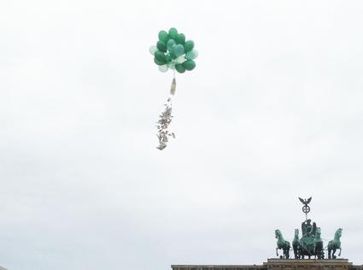 Geldschauer am Brandenburger Tor. Der PEACE-Geldsack beim Öffnen. Sonntag, 12.31 Uhr (10.08.2014). Bild: "obs/PEACE/Daniela Tiben"