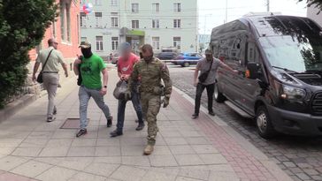 FSB-Mitarbeiter eskortieren einen Einwohner von Kaliningrad, der Terroranschläge geplant haben soll.