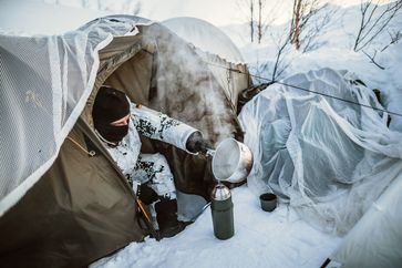 Ein Soldat bereitet seine Verpflegung in einem Ein-Personen-Zelt zu. Bild: Bundeswehr Fotograf: Jana Neumann