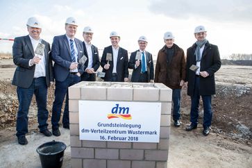 v.l.n.r.: Joachim Lück (Projektleiter dm-VZ Wustermark), Bürgermeister Holger Schreiber, Heinz Ennen (Geschäftsführung Swisslog GmbH), Christian Bodi (dm-Geschäftsführer für das Ressort Logistik), Albrecht Gerber (Minister für Wirtschaft und Energie Brandenburg), dm-Gründer Götz W. Werner und Martin Dallmeier (dm-Geschäftsführer für das Ressort Finanzen + Controlling). Bild: "obs/dm-drogerie markt/Peter-Paul Weiler"