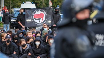 03. Oktober 2022, Sachsen, Leipzig: "Linke" Gegendemonstranten des Bündnisses "Leipzig nimmt Platz" blockieren eine Demonstration mit dem Motto "Für Frieden, Freiheit und Selbstbestimmung".