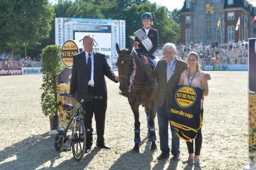 Der Siegerehrung Solartechnik Stiens Nordcup in Münster. V.l.n.r. Georg Stiens (Solartechnik Stiens) mit dem Q-Bike, Meredith Michaels-Beerbaum, Paul Schockemöhle (Geschäftsführer Riders Tour GmbH) und Sabine Kamp. Bild: "obs/Comtainment GmbH"