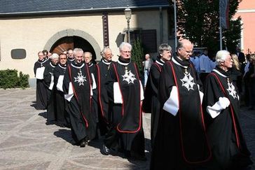 Mitglieder der deutschen Assoziation des Malteserordens in der traditionellen Tracht, der Kukulle. Bild: Malteser