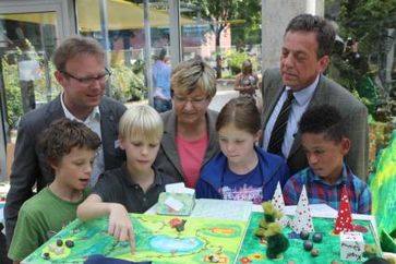 Auszeichnung des UN-Dekade-Projektes "Wölfen auf der Spur" (v.l.n.r.): Frank Corleis, Leiter des SCHUBZ Lüneburg, Frauke Heiligenstadt, Niedersächsische Kultusministerin und Schirmherrin des Ideenwettbewerbs und Helmut Dammann-Tamke, Präsident der Landesjägerschaft Niedersachsen e.V., lassen sich einen Projektbeitrag erklären. Bild: "obs/Zentrum für Umweltkommunikation der Deutschen Bundesstiftung Umwelt ZUK/Landesjägerschaft Niedersachsen"