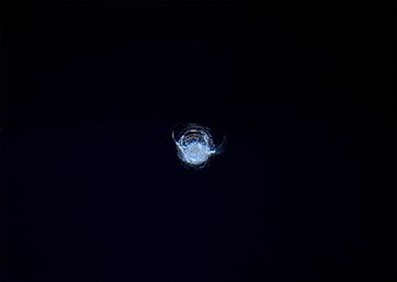 Zentimetergroße Delle in einem Bordfenster des Aussichtsmoduls der ISS. Bild: ESA/NASA