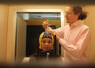 Um eine bessere Übertragungsqualität von Hirnsignalen zu erreichen, tragen die Forscher Kontaktgel auf die Elektroden einer EEG-Kappe auf. Quelle: Foto: Michael Veit (idw)