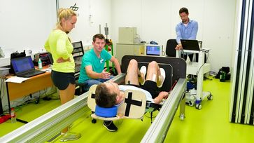 Ein Sprungschlitten macht ein Sprungtraining in horizontaler Lage sowie in Schwerelosigkeit möglich. Rechts im Hintergrund: Dr. Andreas Kramer, der das Trainingskonzept gemeinsam mit Prof. Dr. Markus Gruber an der Universität Konstanz entwickelt hat.