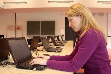 Sandra Fischer, Mitarbeiterin des Servicecenters Lehre der Universität Kassel, bereitet einen Rechner im mobilen E-Klausurcenter für Prüfungen vor.