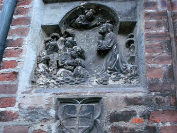 Asylzeichen am Frauendom zu München (Kreuz in einem Schild, unten), unter einer Darstellung der Ölbergszene, die außen an Kirchen Hinweis auf ein Kirchenasyl ist.