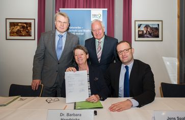 Mit den Unterschriften von DBU-Generalsekretär Dr. Heinrich Bottermann, Bundesumweltministerin Dr. Barbara Hendricks, DBU-Kuratoriumsmitglied Cajus Caesar und Jens Spahn, parlamentarischer Staatssekretär im Bundesfinanzministerium (v.l.) übernimmt die DBU Naturerbe GmbH weitere 23 Flächen mit rund 9.000 Hektar vom Bund. Bild: "obs/Deutsche Bundesstiftung Umwelt (DBU)/Blanka Theime-Dietel/DBU"