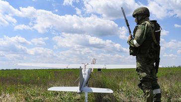 Ein russischer Soldat steht während der Militäroperation in der Ukraine neben einer Drohne vom Typ " Orlan 10". (27. Mai 2022) Bild: Sputnik