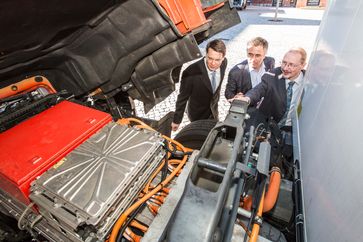 v.l.n.r. Gesamtprojektleiter Prof. Dr. Boris Zimmermann, Praxispartner Markus Bappert, Geschäftsführer Meyer Logistik, und technischer Projektleiter Prof. Dr. Wolfgang Geuer beim Blick in den Motorraum des E-LKW. Das Fahrzeug ist im Rahmen des Forschungsprojekts für die Spedition Meyer Logistik (Friedrichsdorf) im Einsatz. Quelle: Hochschule Fulda / Bild: "obs/Hochschule Fulda/robert gross photography"