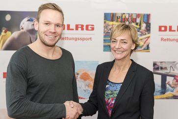 Der amtierende Europameister im Rettungsschwimmen Kai-Uwe Schirmer nimmt stellvertretend für die Deutsche Lebens-Rettungs-Gesellschaft Gratulationen für den Weltrekord von der mehrfachen Olympiasiegerin Heike Drechsler entgegen. Bild: "obs/DLRG - Deutsche Lebens-Rettungs-Gesellschaft/Sascha Walther"