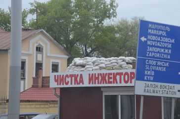Insurgent emplacement in Donetsk, also showing a road sign that points to major conflict areas: Sloviansk and Mariupol.