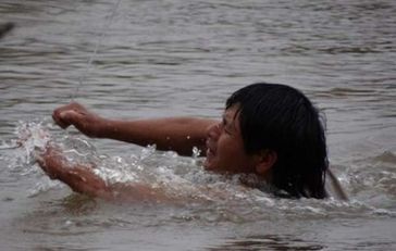 Diese Guarani sind gezwungen an einem dünnen Kabel eine gefährliche Flussüberquerung zu machen, um an Nahrungsmittel zu gelangen. Bild: Survival