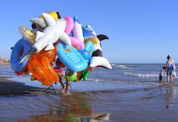 Gummitiere und andere aufblasbare Badespielzeuge eines fliegenden Händlers an einem Badestrand