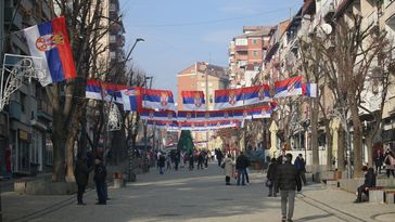 Blick auf eine Straße in Mitrovica, Nord-Kosovo, am 30. Dezember 2022, die mit serbischen Fahnen für die Neujahrsfeierlichkeiten geschmückt ist. Bild: Gettyimages.ru / Erkin Keci / Anadolu Agency