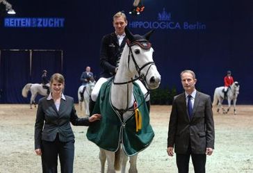 Großer Preis der Hippologica 2013 - Berlin-Brandenburg-Masters,Springprüfung Kl.S** Sieger ist André Thieme vom German Horse Pellets e.V. auf Ramona de Flobecq. Es gratuliert Kerstin Ebel, Projektleiterin der Messe Berlin GmbH (li.) und Peter Fröhlich, Geschäftsführer Sport im Landesverband Pferdesport Berlin-Brandenburg e.V. (LPBB) (re.) Bild: obs/Messe Berlin GmbH/Volkmar Otto