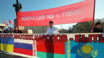 Archivbild: Eine Kundgebung zum 97. Jahrestag der Oktoberrevolution. Auf den Schildern steht: "Noworossija! Wir sind mit dir!" und "Union brüderlichen Völker: Sie soll sein!" (Simferopol, Russland, 7. November 2014) Bild: Sputnik / Taras Litwinenko