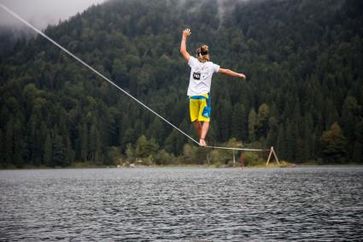 HD+ Testimonial Alex Schulz hat seinen im Rahmen der "Mission: HD für Helgoland" - Kampagne aufgestellten Weltrekord im Slacklinen über Wasser gebrochen: Am Eibsee hat er 320 Meter über Wasser zurückgelegt. Bild: "obs/HD PLUS GmbH/Johannes Olszewski/HD PLUS GmbH"