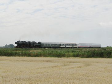 Von einer Dampflok gezogener Zug auf der Fahrt von Dagebüll nach Niebüll (IC-Kurswagen am Zugende)