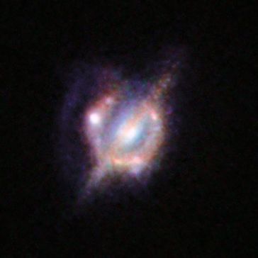 Verschmelzende Galaxien im frühen Universum unter einer kosmischen Lupe.