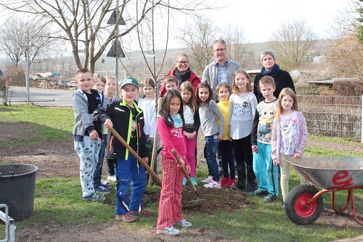 Ausgestattet mit Schaufel und Schubkarre hat die Schulgarten AG ihre eigenen Bäume im Schulgarten eingepflanzt. Gunter Jenne, Geschäftsführer von NaturEnergiePlus war mit dabei und hat den Kindern alle Fragen rund um das Thema Umwelt beantwortet. Bild: "obs/NaturEnergie+ Deutschland GmbH/NaturEnergiePlus"