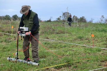 Untersuchung des «Piano del Tamburino» mittels geophysikalischer Prospektion, um im Boden liegende Strukturen zu entdecken. Im Vordergrund führt ein Forscher eine elektrische Flächenkartierung durch, im Hintergrund findet eine geomagnetische Kartierung statt.
Quelle: Bild: IAW Universität Bern, Archäologie des Mittelmeerraumes. (idw)