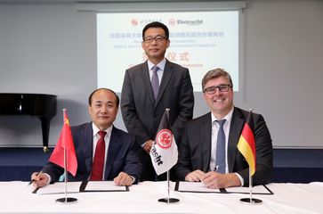 Generalkonsul Wang Shunqing (stehend) bei der Vertragsunterzeichnung von BSU-Direktor Cao Weidong und Axel Hellmann. Bild: Eintracht Frankfurt