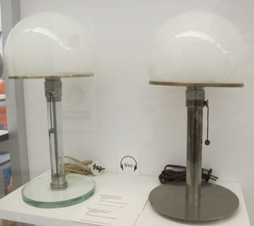 Die linke Leuchte ist eine 1923–24 entstandene Ausführung von Jucker, die rechte eine 1924 entstandene Ausführung von Wagenfeld