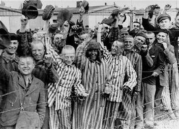 Häftlinge, teilweise in gestreifter KZ-Häftlingskleidung, nach der Befreiung des Konzentrationslagers Dachau. Aufnahme vom 29. April 1945.