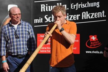 Michael Mittermeier und Finalist Rainer Bothe beim Selbstversuch auf dem Finale des Rivella-Alphornlautblaswettbewerbs. Bild: Andreas Gebert/obs/Rivella AG