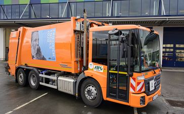 Die Müllwagen der Abfallwirtschaftsgesellschaft mbH Wuppertal (AWG) fahren mit Engels-Plakaten durch die Stadt.