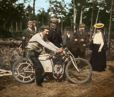 Der 'reisende Schmied' Václav Vondrich mit seiner Ledertasche voller Werkzeug und Ersatzteile war am 25. Juni 1905 Sieger der inoffiziellen Motorrad-Weltmeisterschaft in Dourdan (Frankreich). Rechts neben ihm steht Fabrikbesitzer Václav Klement. Bild: Skoda Auto Deutschland GmbH Fotograf: Skoda Auto Deutschland GmbH